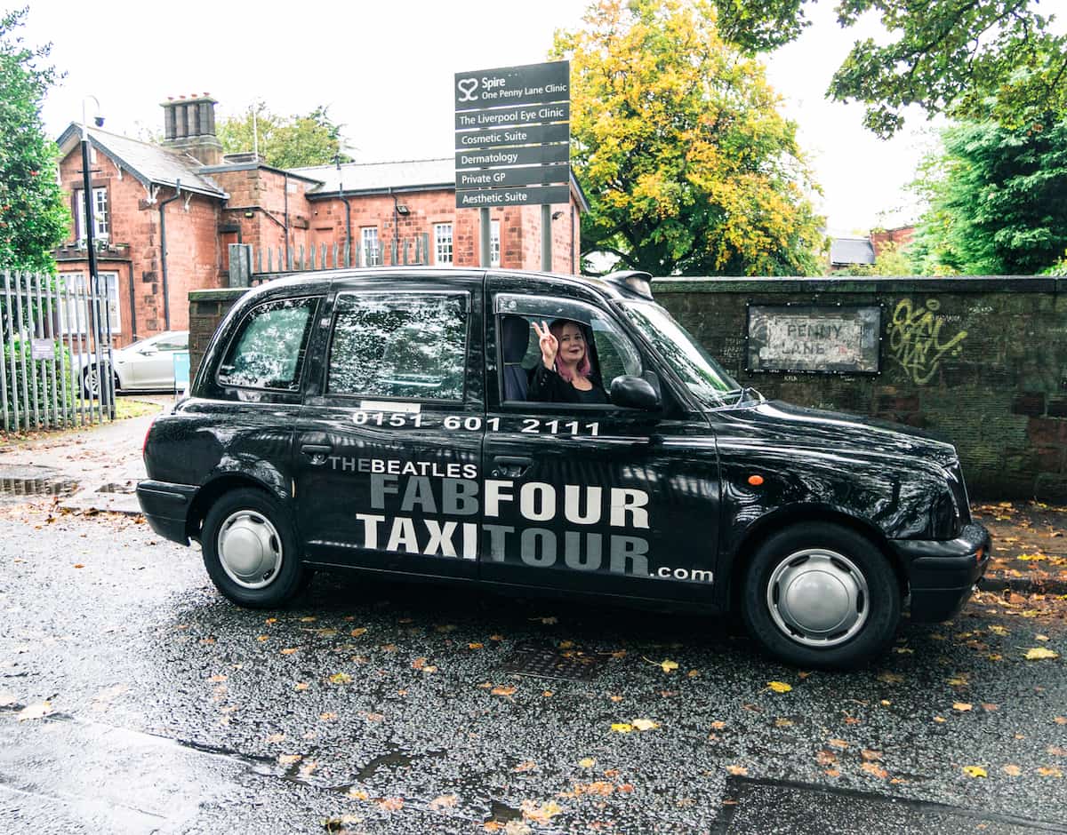 Fab four taxi tour cab infront of Penny Lane sign