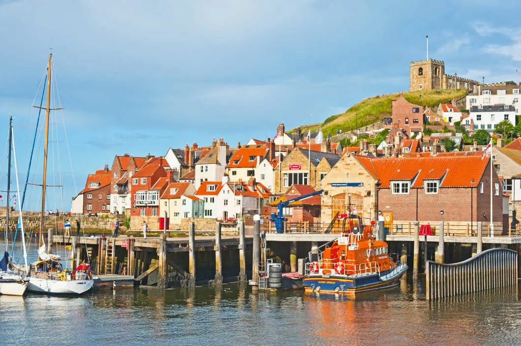 Whitby in Yorkshire with yachts and Saint Mary's Church in the background.