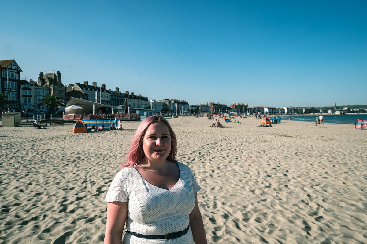 Kat standing in front of weymouth beach
