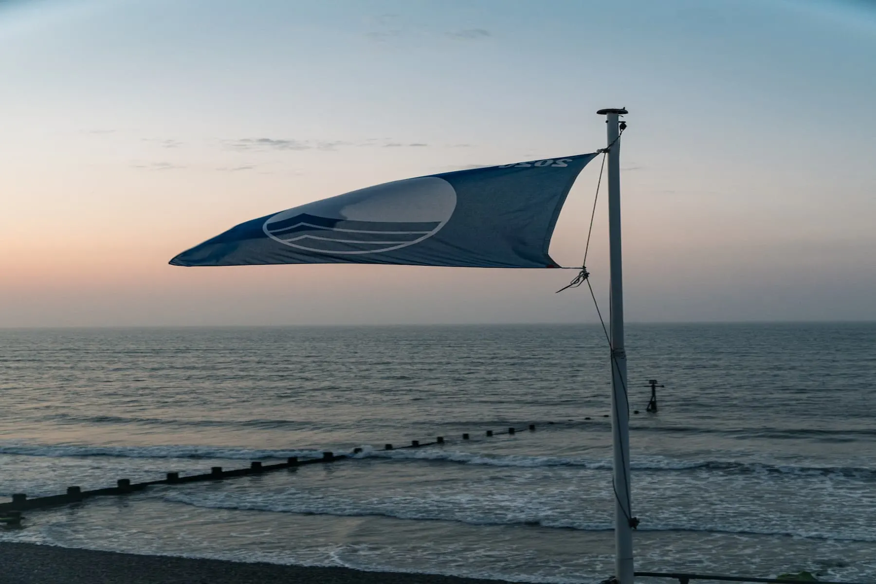 flag flying in the wind at Sheringham beach