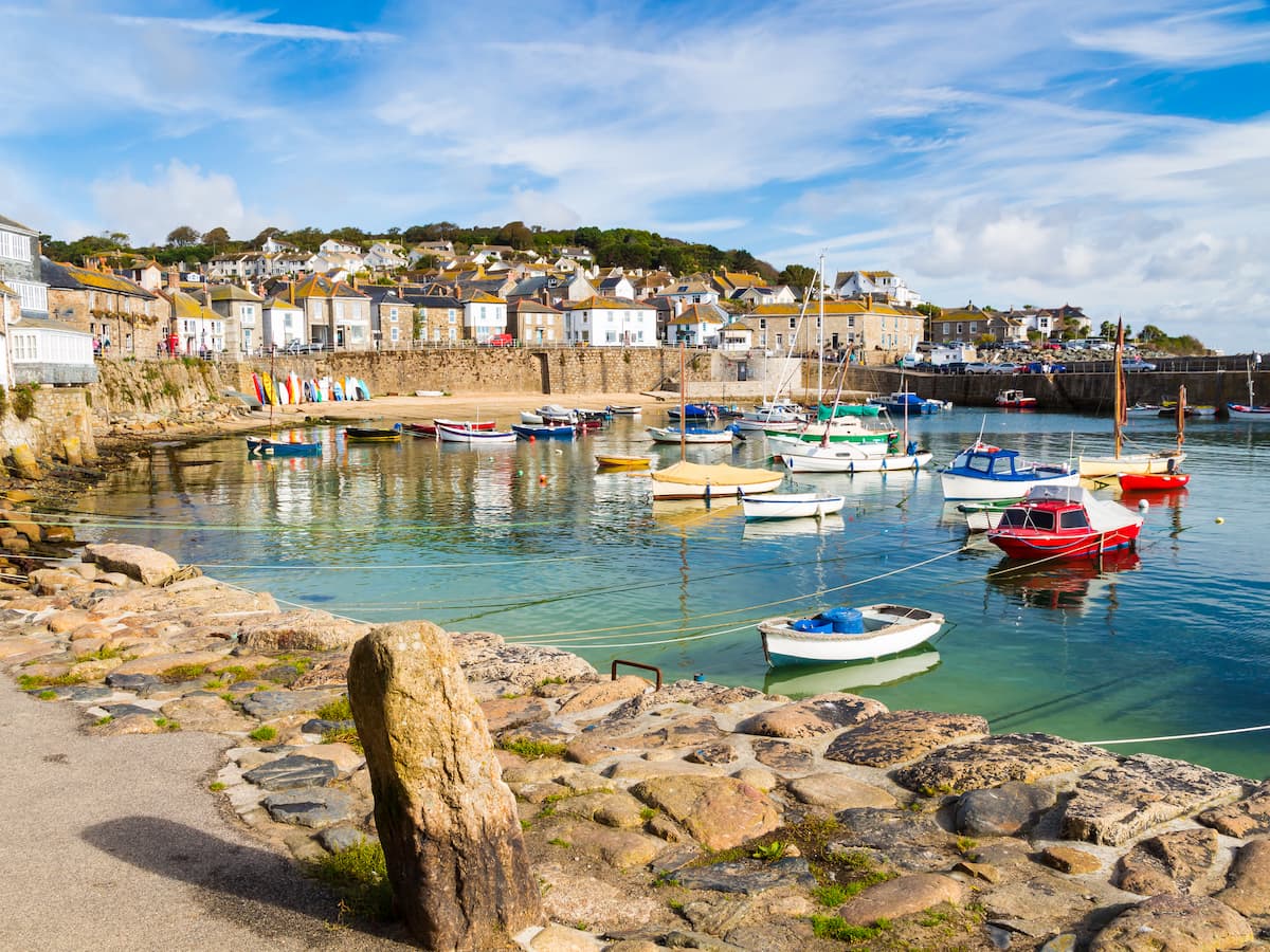 Fishing town of Mousehole Cornwall. With small boats and a backdrop of the town.