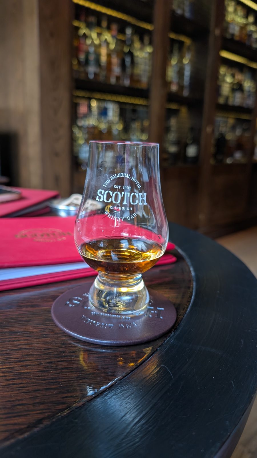 Glass of Scotch on a barrel table in the whisky bar at the Balmoral Hotel, Edinburgh.