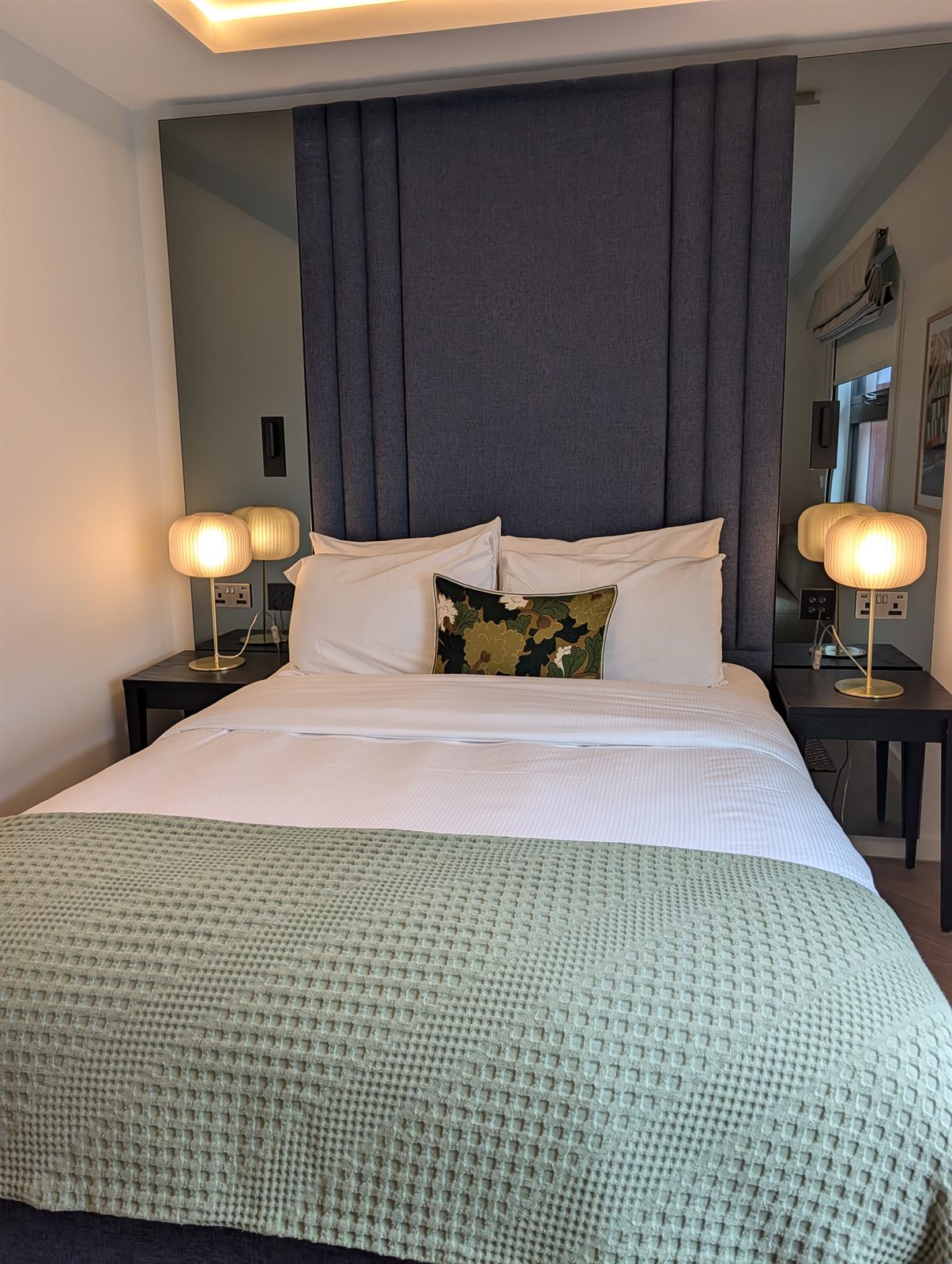 Room at the Hobson in Cambridge with a green throw and brass bedside lamps