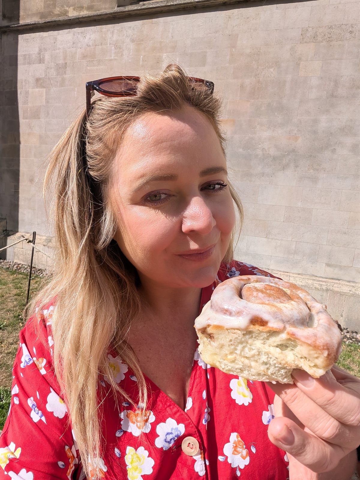 Kat eating a cinnamon bun outside in Cambridge