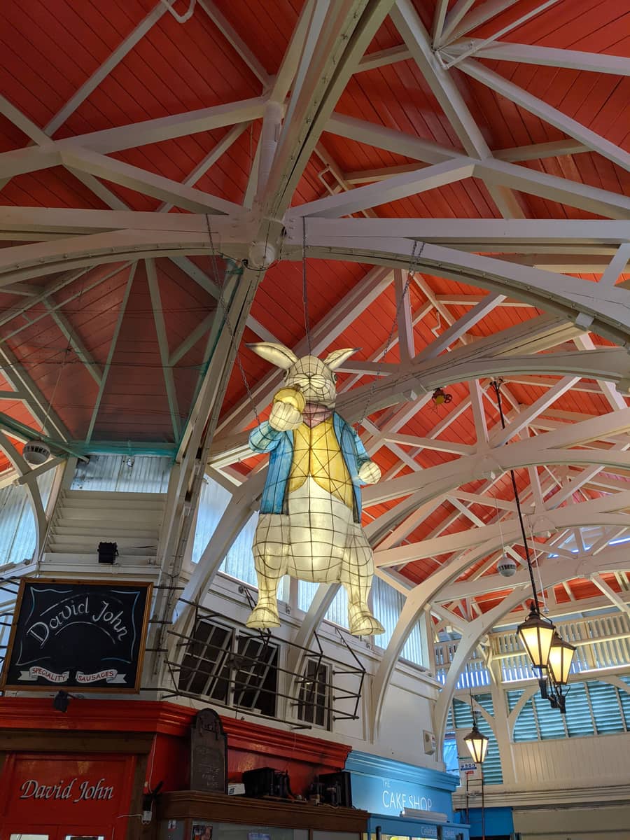 The White Rabbit lantern hanging from the red roof of the Covered Market in Oxford