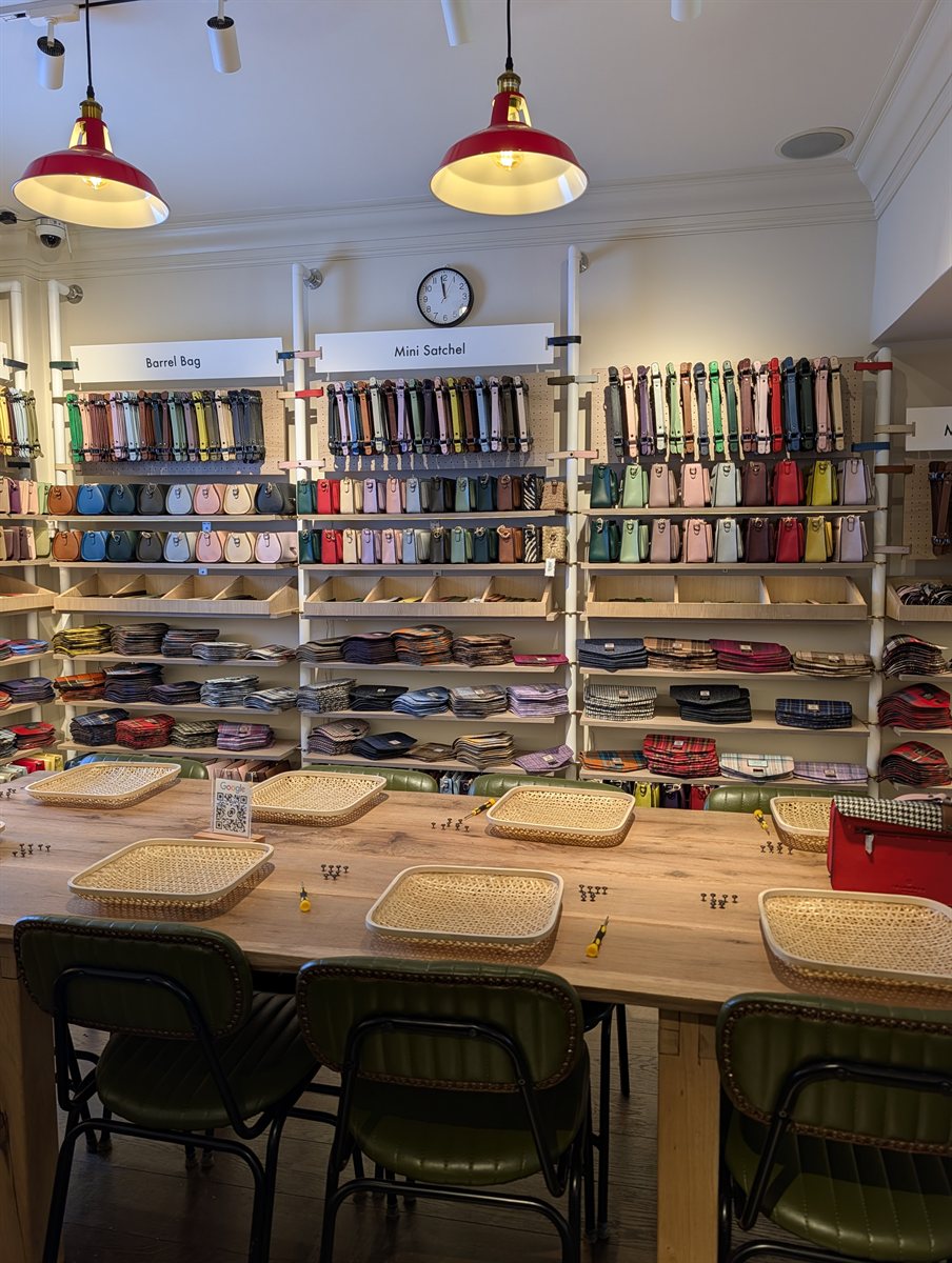 The Islander workshop room, a long wooden table with trays and screwdrivers under shelves of lids, bodies and straps