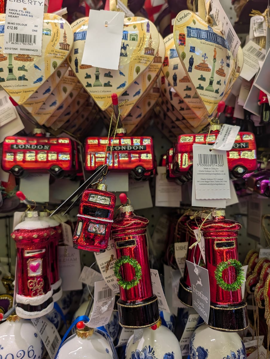 Glass London bus and postbox Christmas ornaments hanging beneath Trafalgar Square hearts at Liberty