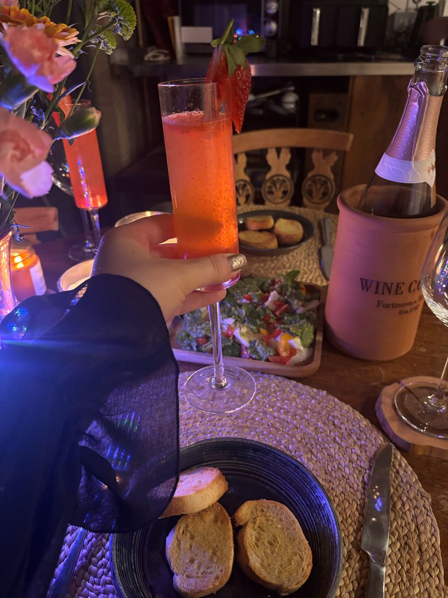 Terracotta Fortnum & Mason wine cooler holding a pink sparkling bottle on a dinner table
